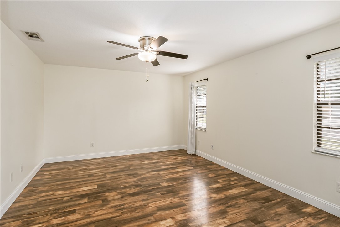 1121 Clearmont Street Sebastian, FL 32958 - Photo 20 of 31 an empty room with wooden floor fan and windows
