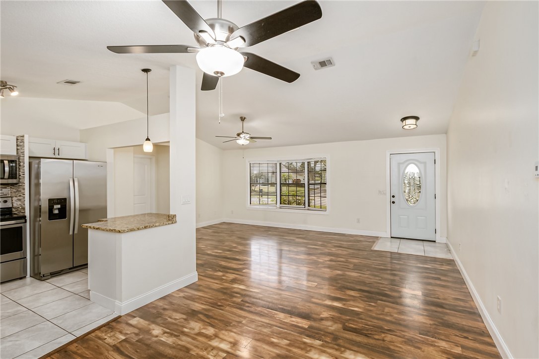 1121 Clearmont Street Sebastian, FL 32958 - Photo 9 of 31 an empty room with a kitchen and a ceiling fan