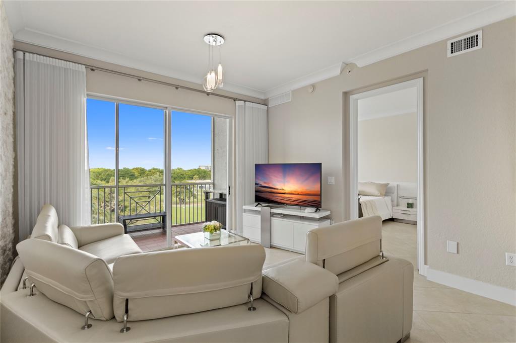 3500 Oaks Clubhouse Drive, Unit 505 Pompano Beach, FL 33069 - Photo 13 of 33 a living room with furniture and a flat screen tv