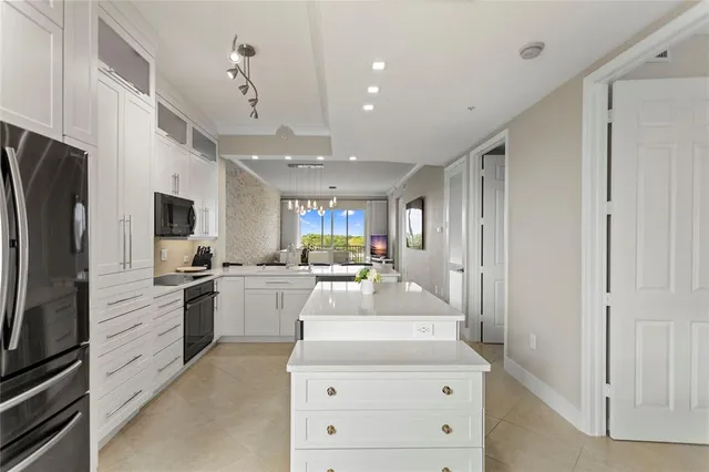 a kitchen with stainless steel appliances kitchen island granite countertop a refrigerator and a stove top oven