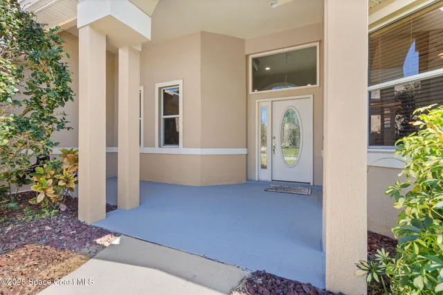 a view of a hallway with wooden floor and a bathroom