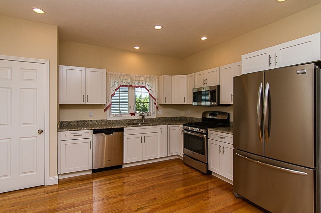 a kitchen with stainless steel appliances granite countertop a refrigerator stove and sink