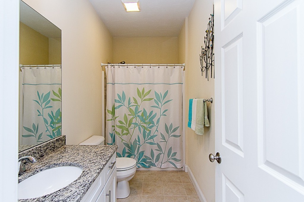 19 Geordan Avenue Bellingham, MA 02019 - Photo 13 of 22 a bathroom with a granite countertop sink a toilet and shower curtain
