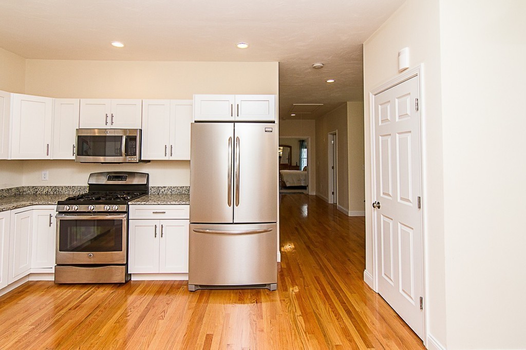 19 Geordan Avenue Bellingham, MA 02019 - Photo 6 of 22 a kitchen with kitchen island wooden floors appliances and cabinets