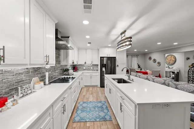 a large white kitchen with a large counter top appliances and cabinets