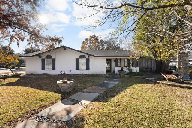 a view of a white house with a large tree