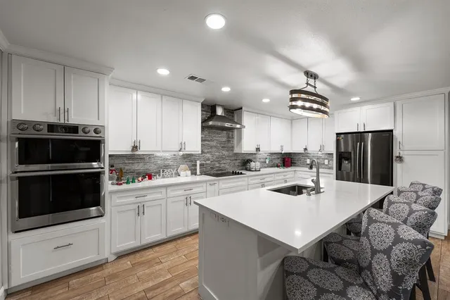 a kitchen with a sink a stove top oven and refrigerator