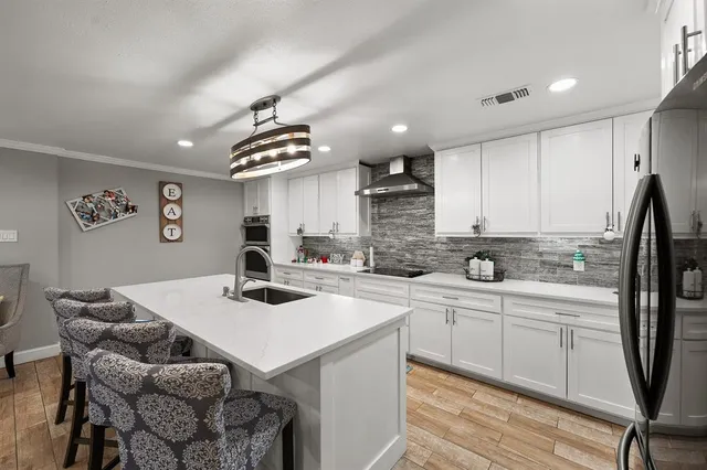 a kitchen with a sink a stove a refrigerator and cabinets