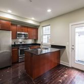 a kitchen with stainless steel appliances granite countertop a refrigerator a sink and a stove
