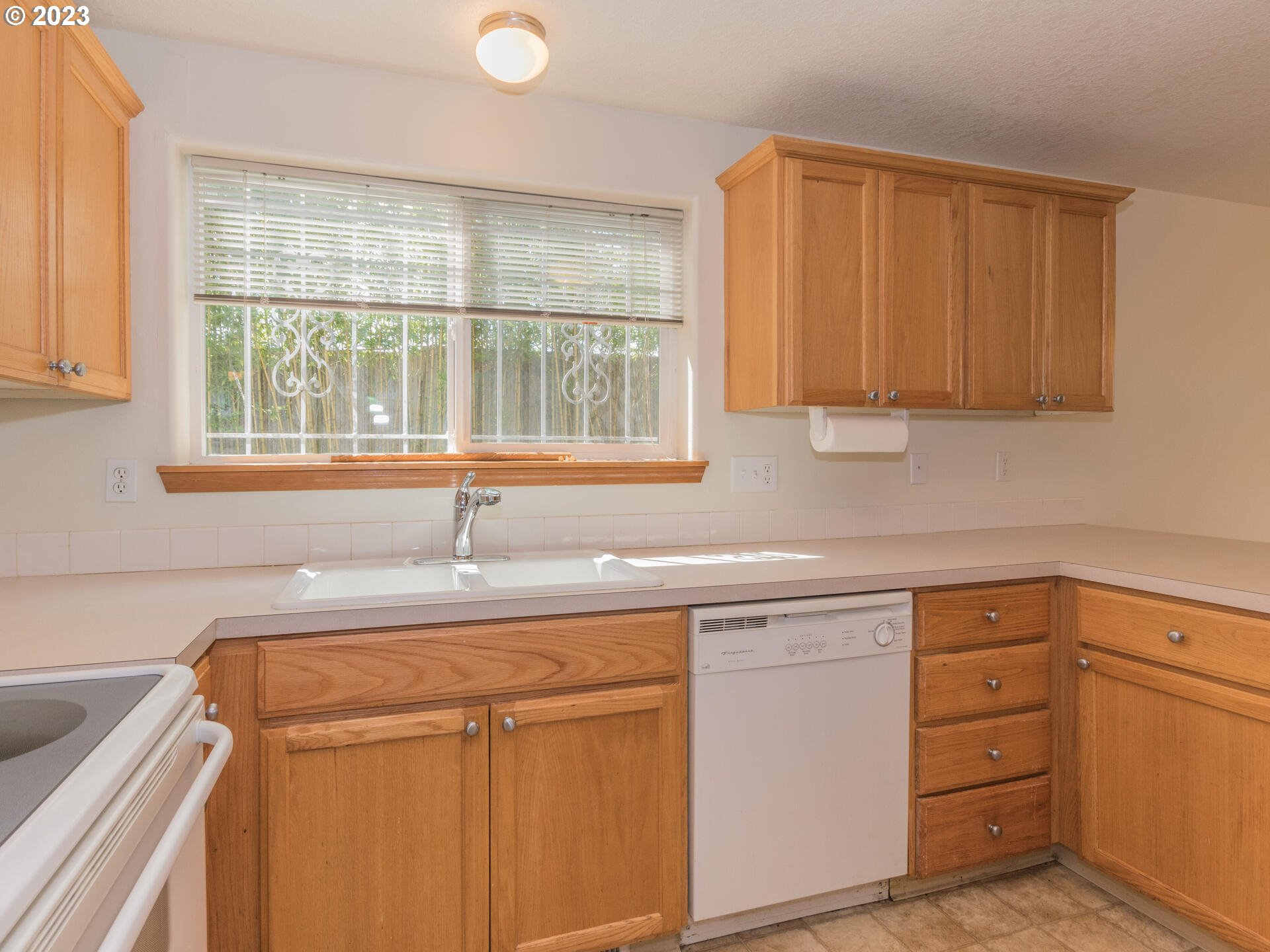 1058 Southwest Ivory Loop Gresham, OR 97080 - Photo 15 of 31 a kitchen with granite countertop cabinets sink and window