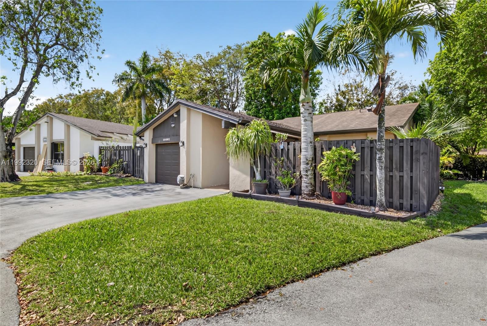 10861 Southwest 132nd Cir Court Miami, FL 33186 - Photo 2 of 42 a front view of a house with a yard and potted plants