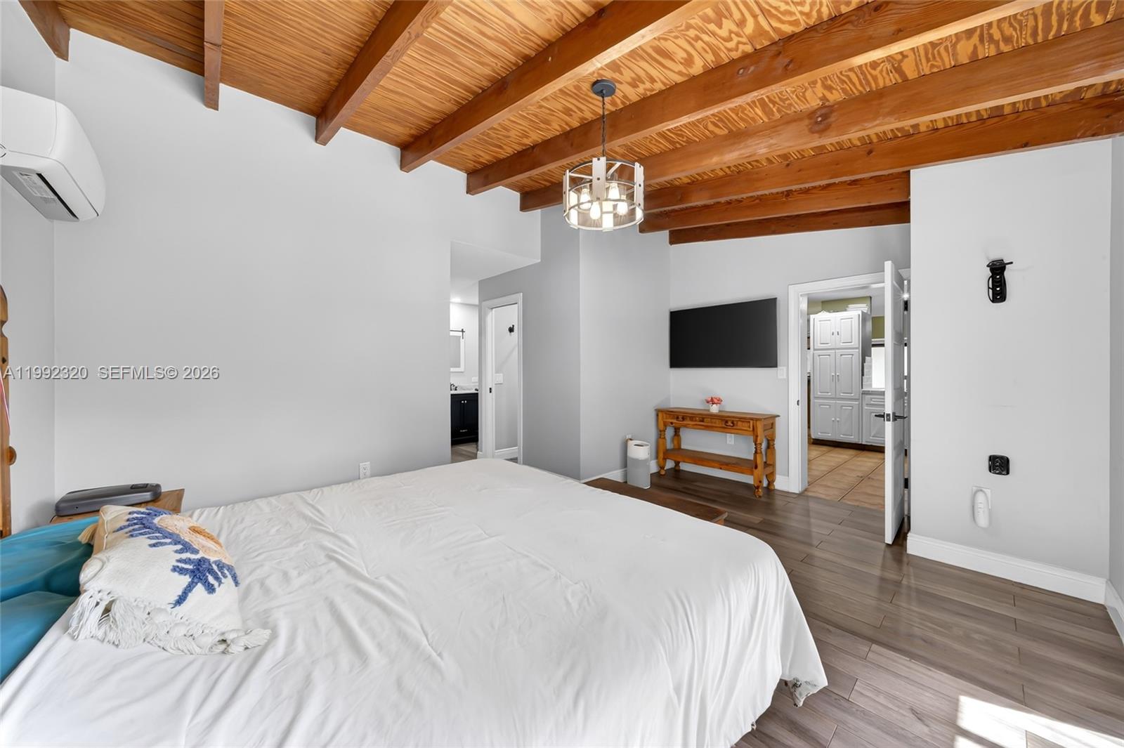 10861 Southwest 132nd Cir Court Miami, FL 33186 - Photo 30 of 42 a bedroom with a large bed a flat tv screen and a chandelier