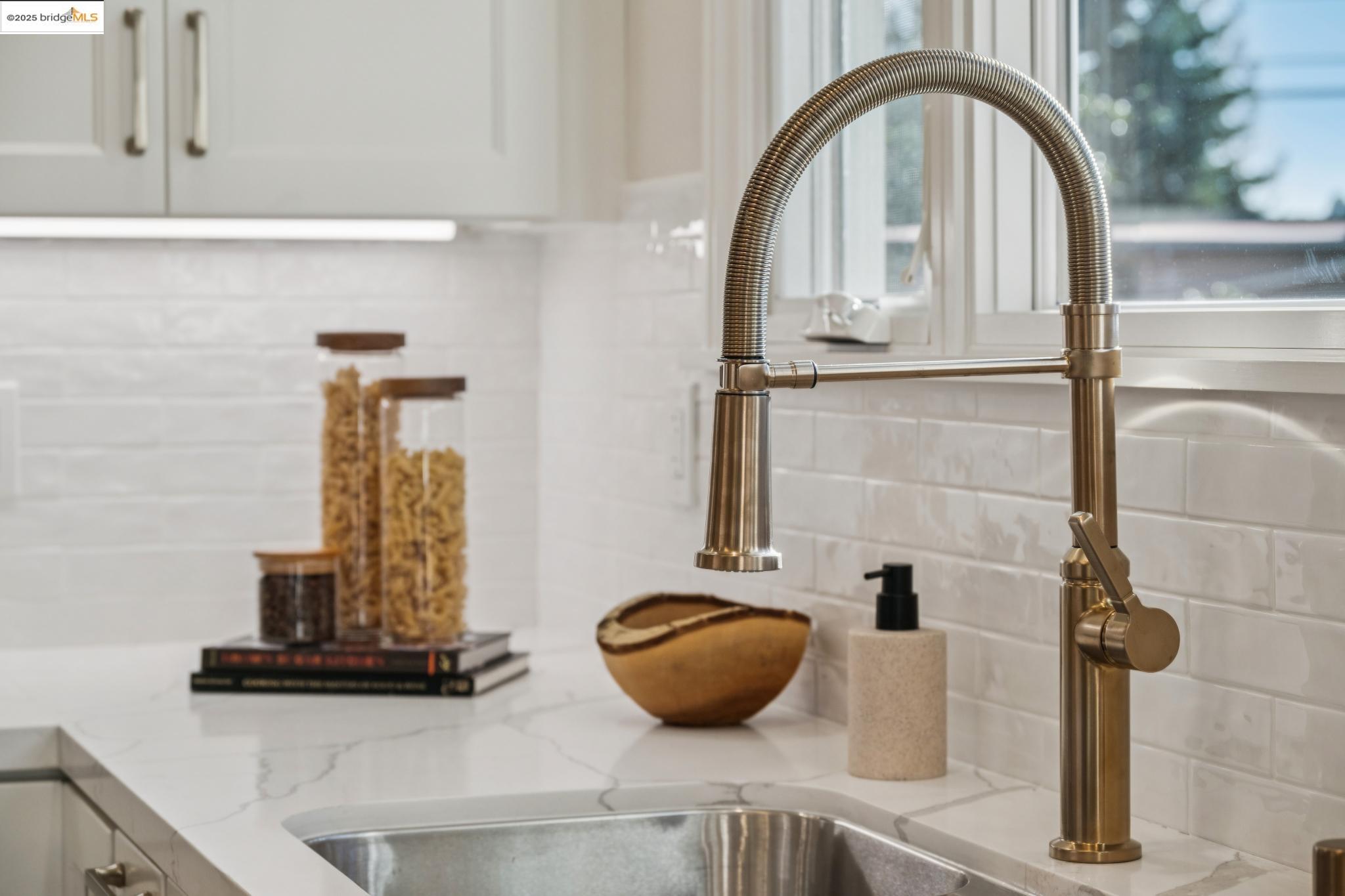 1833 Sonoma Avenue Berkeley, CA 94707 - Photo 21 of 57 Kitchen view of backsplash with subway tile, light stone counters, and white cabinets