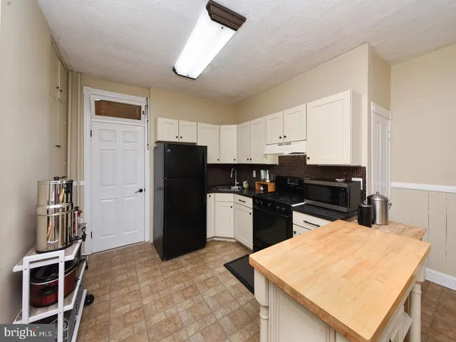 a kitchen with a refrigerator and a stove top oven