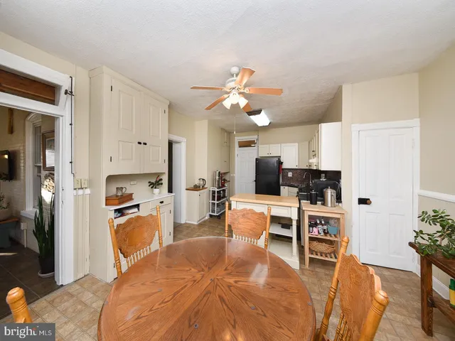 a living room with furniture kitchen view and a refrigerator