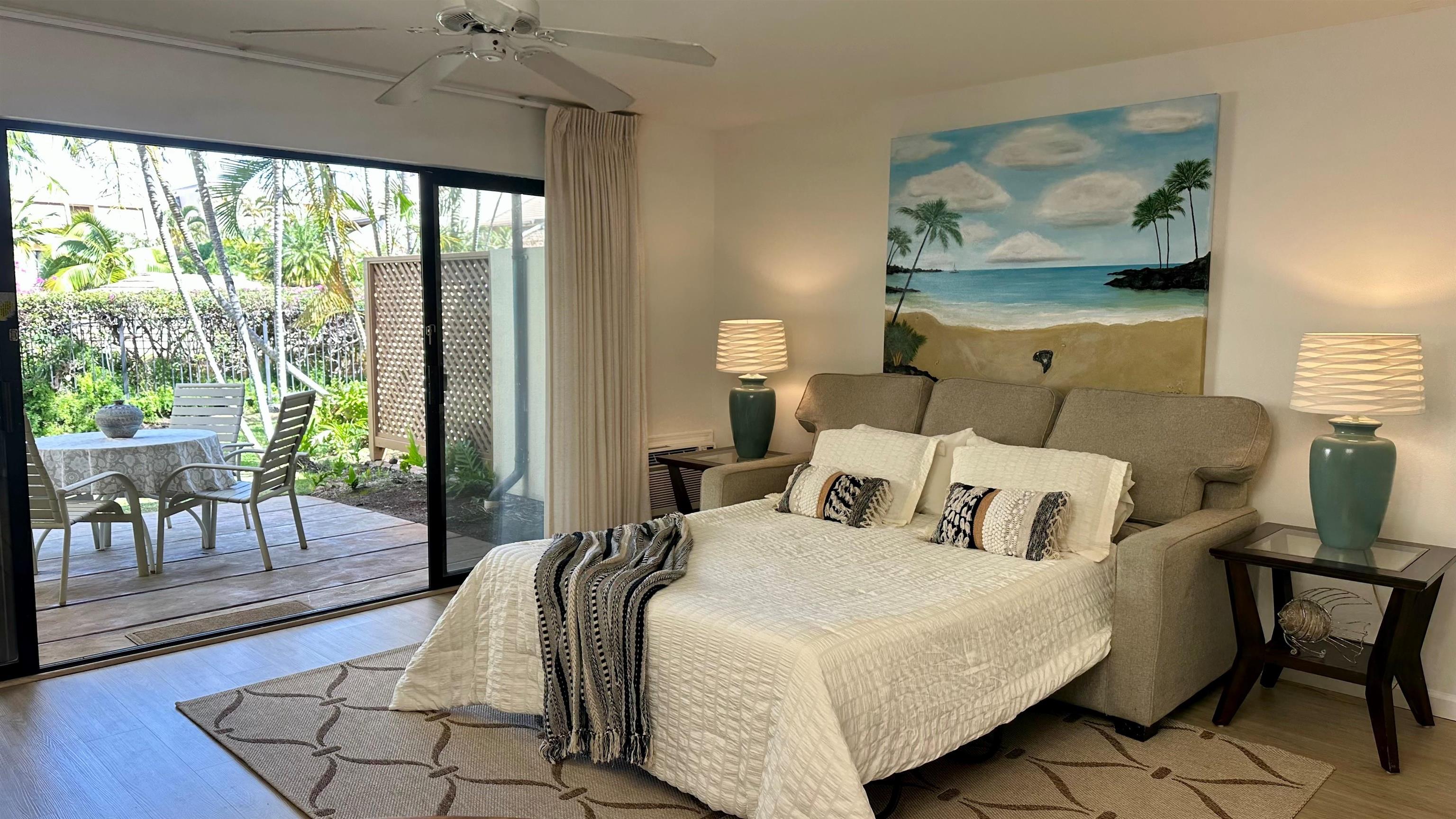 2777 South Kihei Road, Unit K102 Kihei, HI 96753 - Photo 2 of 47 a bedroom with a bed a lamp and large window with garden view