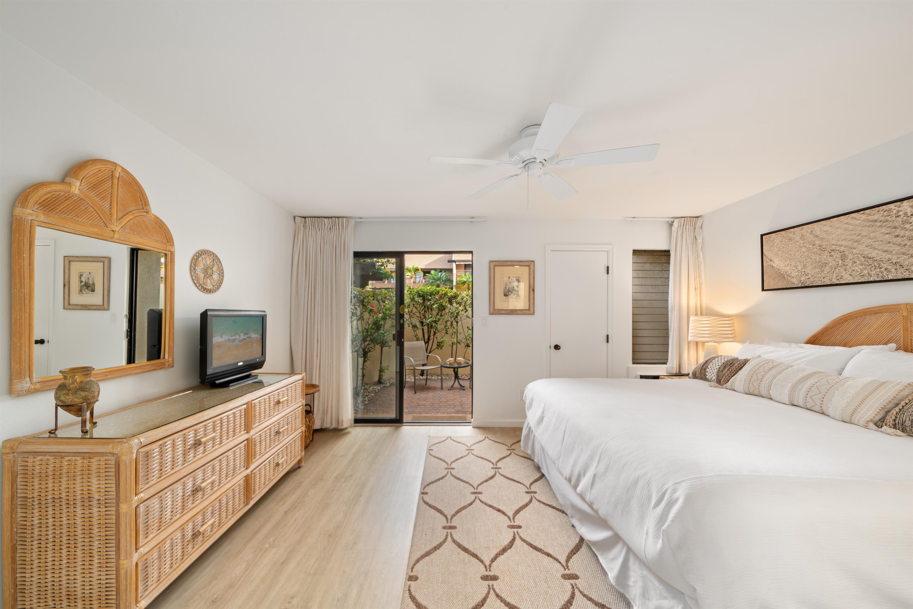 2777 South Kihei Road, Unit K102 Kihei, HI 96753 - Photo 29 of 47 a bedroom with a large bed and a flat tv screen on dresser