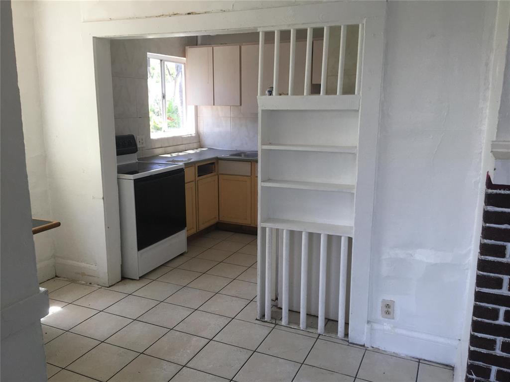 124 Daytona Avenue, Unit 2 Holly Hill, FL 32117 - Photo 2 of 6 a kitchen with granite countertop a stove a sink and a refrigerator
