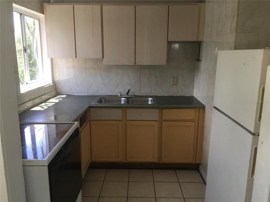 124 Daytona Avenue, Unit 2 Holly Hill, FL 32117 - Photo 3 of 6 a kitchen with a refrigerator and a stove