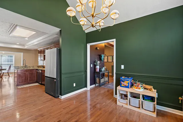 a bedroom with a bed a flat screen tv and a chandelier