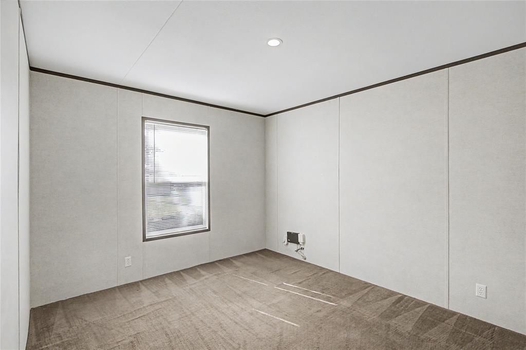 177 New Highland Road Springtown, TX 76082 - Photo 27 of 40 Interior room featuring light-colored wall panels and a textured brown carpet