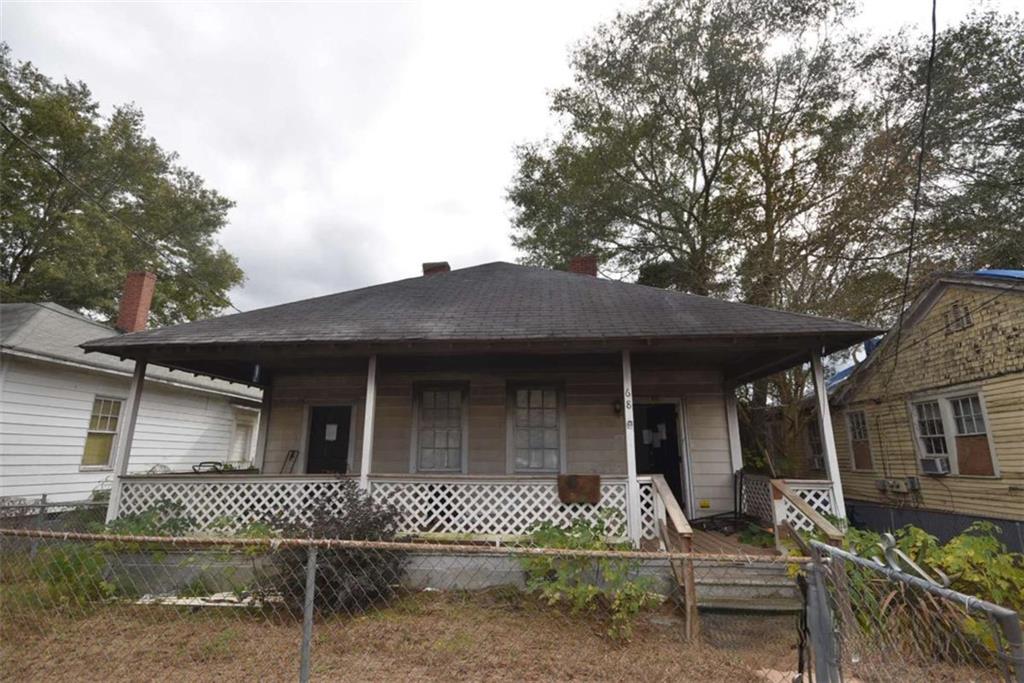 68 Poplar Street Porterdale, GA 30014 - Photo 1 of 13 front view of a house with a bench