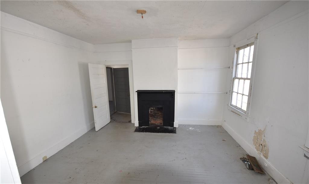 68 Poplar Street Porterdale, GA 30014 - Photo 12 of 13 an empty room with windows and fireplace