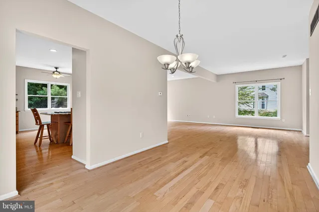 a view of empty room with wooden floor and window