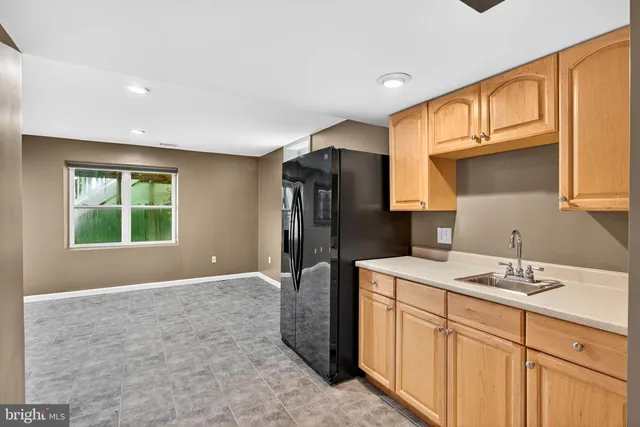a kitchen with a sink a refrigerator and cabinets
