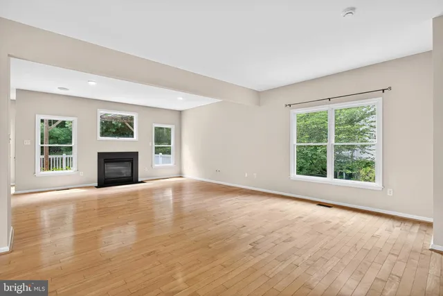 a view of empty room with wooden floor and fireplace
