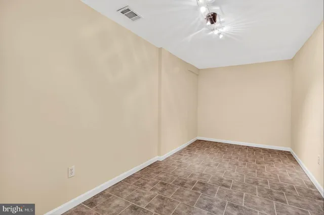 an empty room with a ceiling fan and carpet
