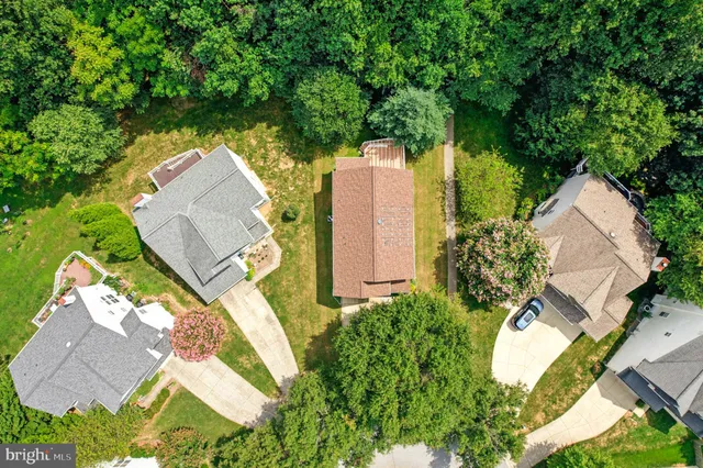 an aerial view of a house with a yard and a large tree
