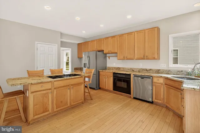 a kitchen with stainless steel appliances granite countertop a stove sink and cabinets