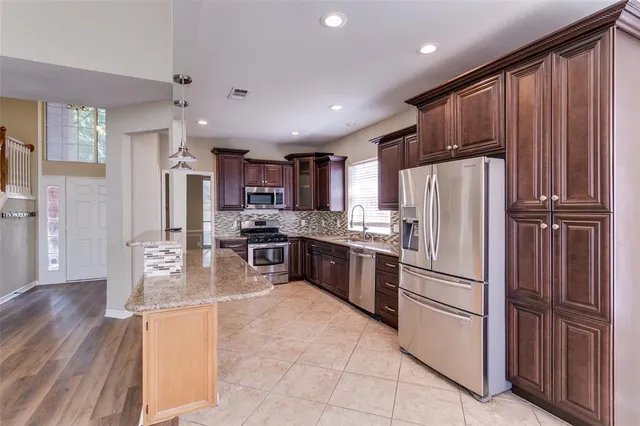 a kitchen with stainless steel appliances a refrigerator and a stove top oven