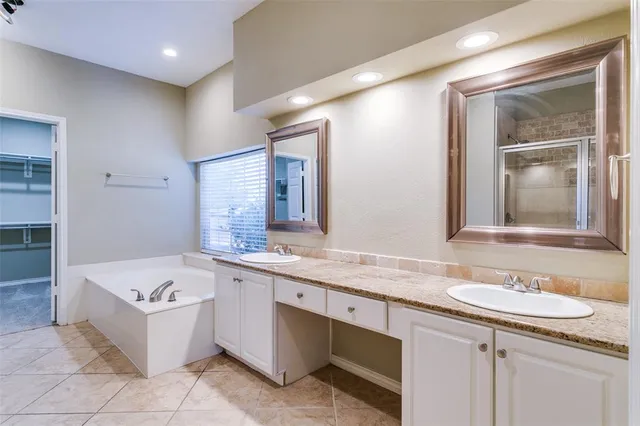 a bathroom with a tub sink and mirror
