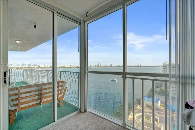 a living room with furniture a flat screen tv and a floor to ceiling window