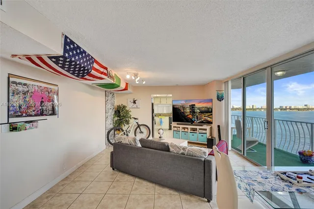 a living room with furniture a flat screen tv and a large window