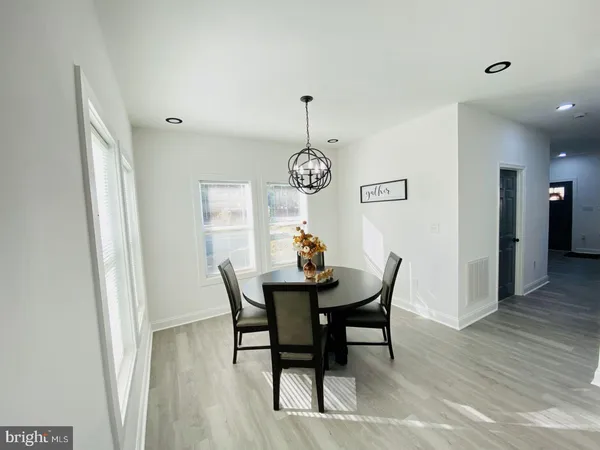 a kitchen with stainless steel appliances granite countertop a sink a stove a refrigerator a center island a dining table and chairs