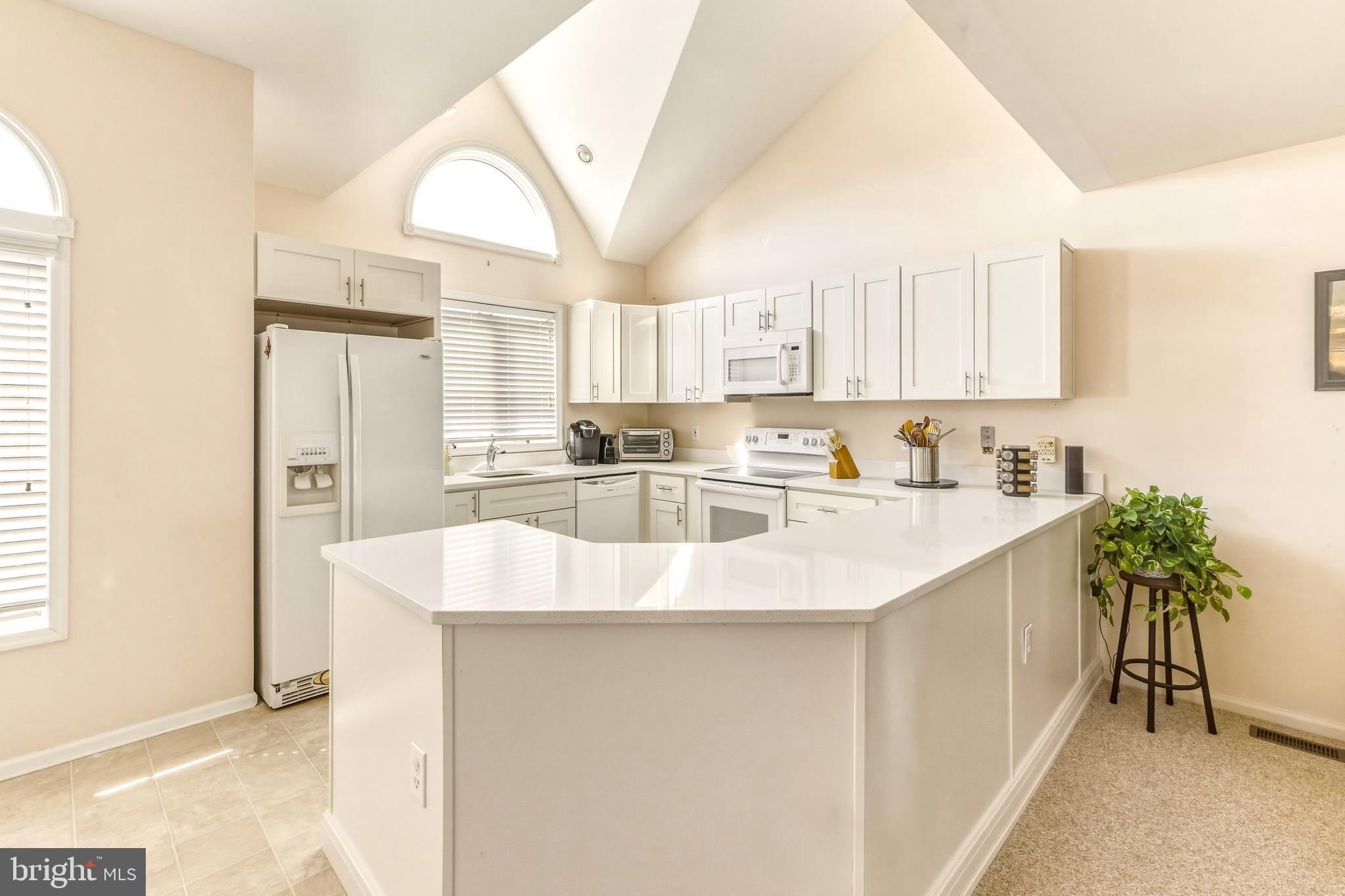 301 Gull Cove Brigantine, NJ 08203 - Photo 12 of 40 a kitchen with kitchen island granite countertop a sink a counter top space and cabinets