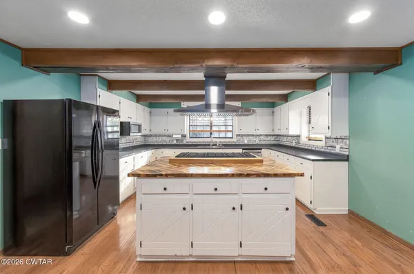 a kitchen with stainless steel appliances granite countertop a refrigerator a sink and a stove