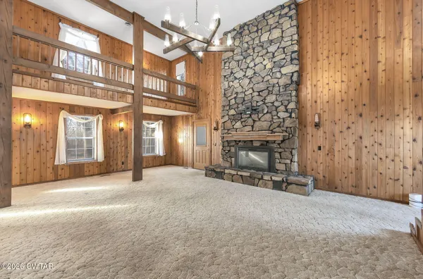 a view of an empty room with a fireplace and a window