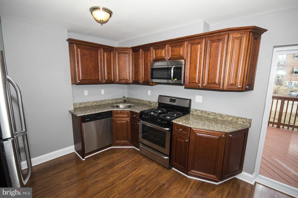 33 Eastship Road Baltimore, MD 21222 - Photo 4 of 23 a kitchen with granite countertop wooden cabinets and a stove top oven