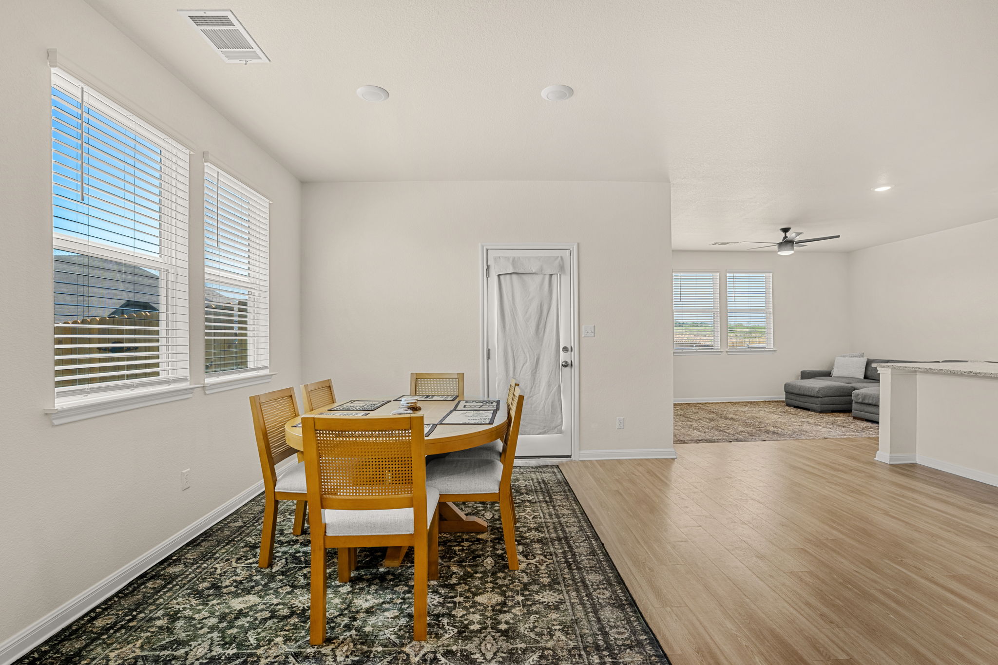 148 Hidalgo Lane Elgin, TX 78621 - Photo 13 of 38 Natural light floods this inviting dining area with practical wood flooring leading into an open living space.