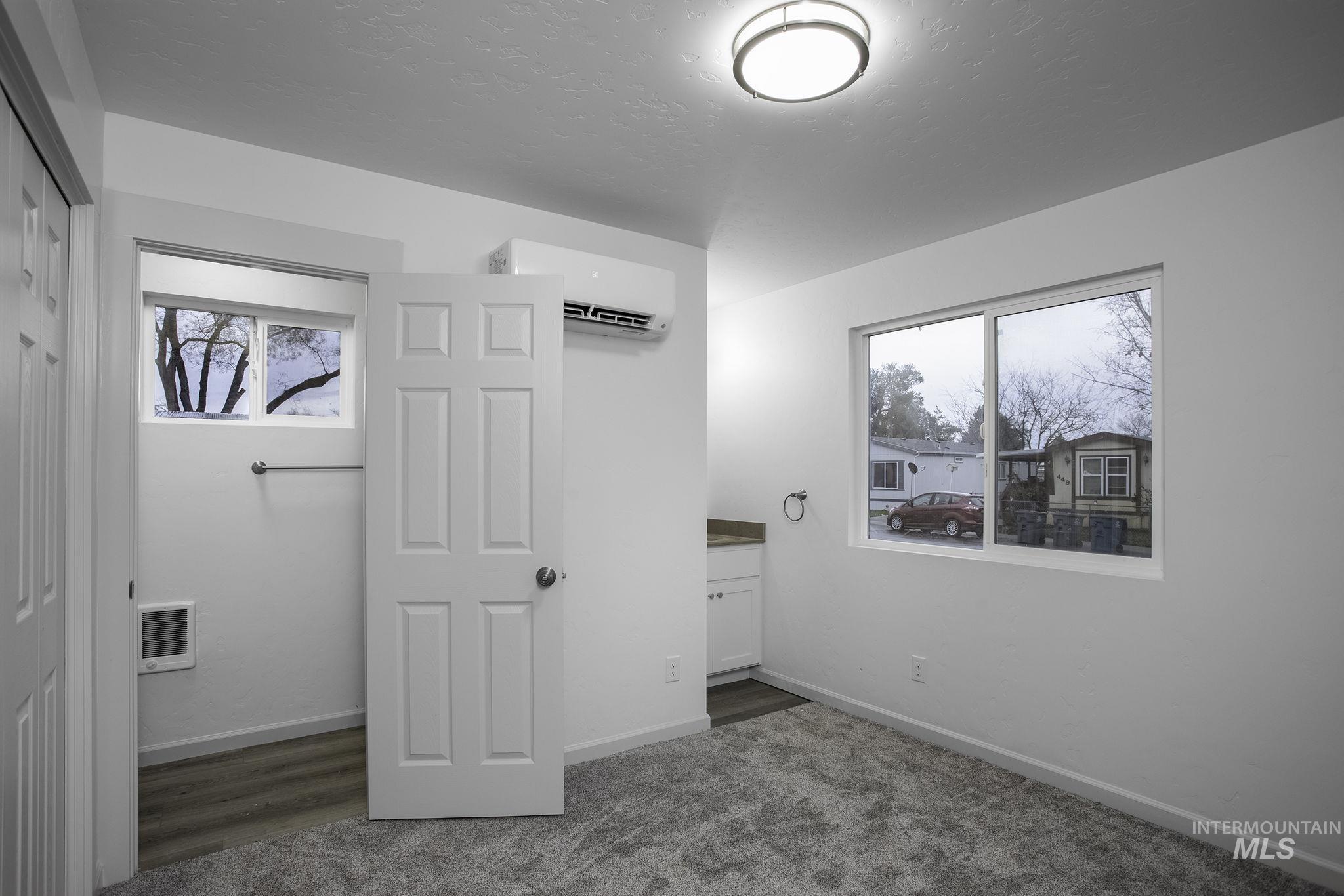 450 Greenleaf Street Boise, ID 83713 - Photo 7 of 17 Unfurnished bedroom featuring a closet, a wall unit AC, dark carpet, heating unit, and a textured ceiling