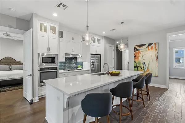 a large white kitchen with a large window a refrigerator a sink and dishwasher