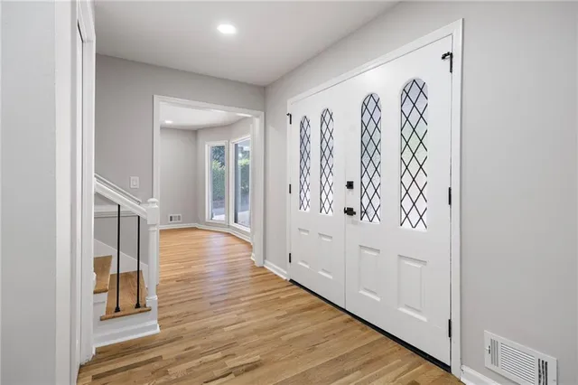 a view of a hallway with wooden floor and staircase