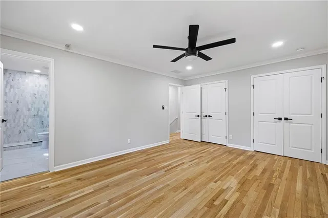 a view of empty room with wooden floor and ceiling fan