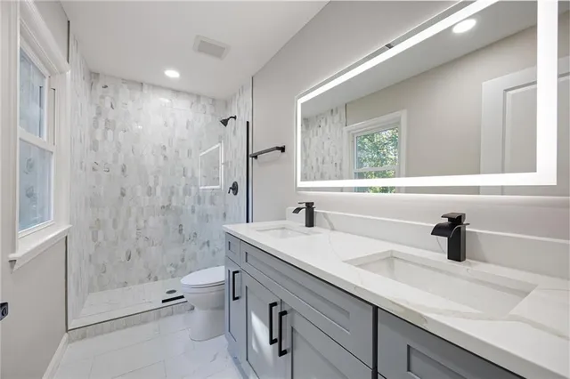 a bathroom with a sink a toilet and shower