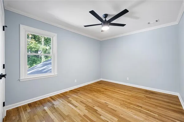 a view of a big room with wooden floor and windows