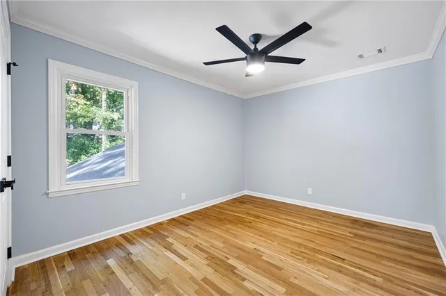 a view of a big room with wooden floor and windows